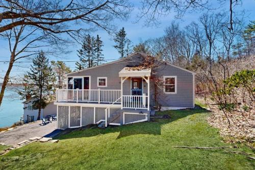 Dog-friendly river-view home with wood stove, deck, patio, dock, beach, grill